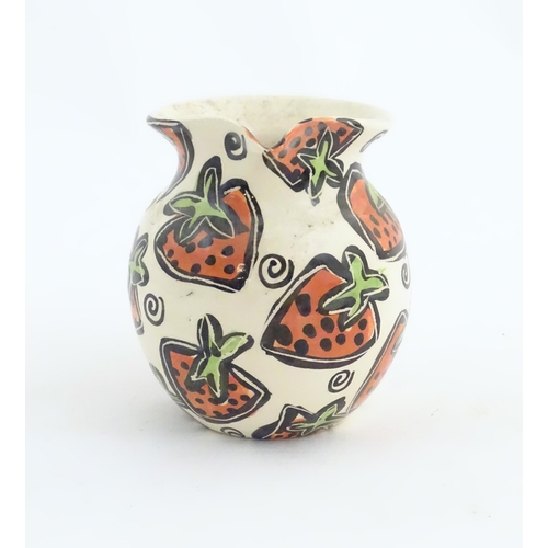 166 - A studio pottery jug and bowl decorated with hand painted strawberry detail by Liz Riley. Marked und... 