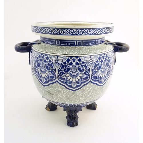 171 - A large Victorian Minton blue and white jardiniere / planter with twin handles standing on four feet... 