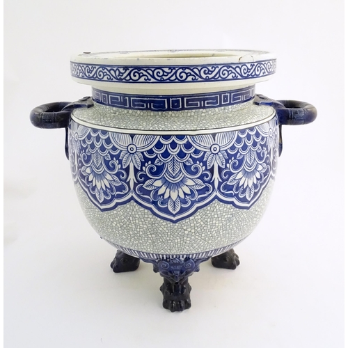 171 - A large Victorian Minton blue and white jardiniere / planter with twin handles standing on four feet... 