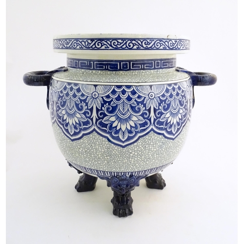 171 - A large Victorian Minton blue and white jardiniere / planter with twin handles standing on four feet... 