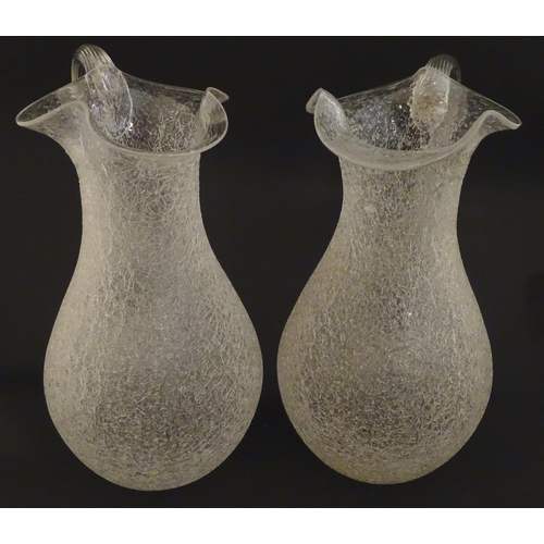 222 - A pair of late 19thc / early 20thC lemonade / Kalte Ente jugs. The crackle glass jugs with loop hand... 