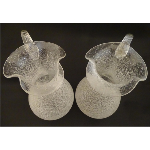 222 - A pair of late 19thc / early 20thC lemonade / Kalte Ente jugs. The crackle glass jugs with loop hand... 