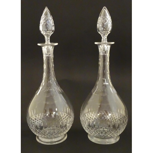 223 - A pair of late 19thC / early 20thC glass decanters and stoppers with cut decoration. Approx 14