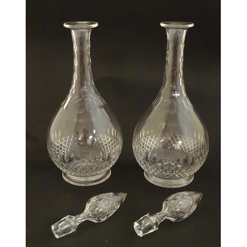 223 - A pair of late 19thC / early 20thC glass decanters and stoppers with cut decoration. Approx 14