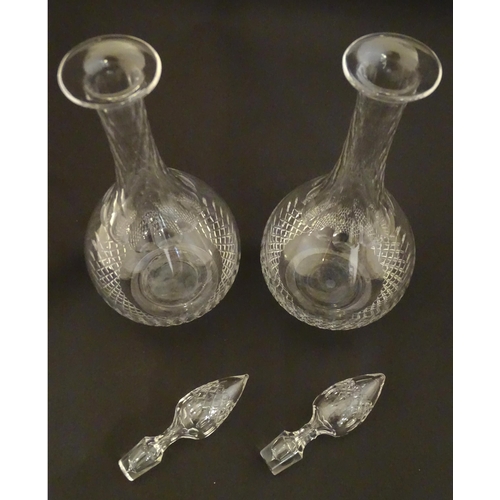 223 - A pair of late 19thC / early 20thC glass decanters and stoppers with cut decoration. Approx 14