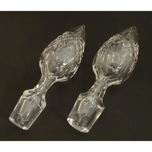 223 - A pair of late 19thC / early 20thC glass decanters and stoppers with cut decoration. Approx 14