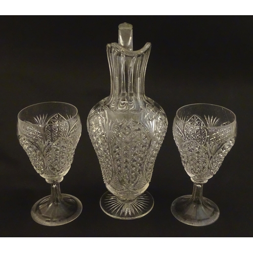 224 - A cut glass claret jug with a pair of cut glass pedestal drinking glasses. The jug 10 1.2