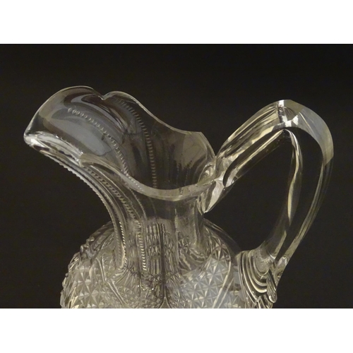 224 - A cut glass claret jug with a pair of cut glass pedestal drinking glasses. The jug 10 1.2