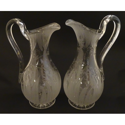 228 - A pair of 19thC jugs with etched decoration depicting floral and foliate detail probably by Richards... 