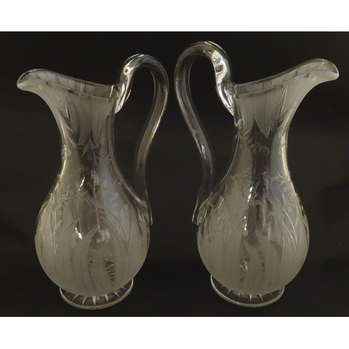 228 - A pair of 19thC jugs with etched decoration depicting floral and foliate detail probably by Richards... 