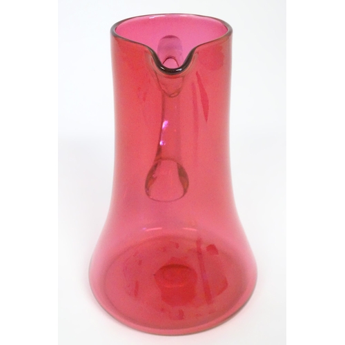 245 - A cranberry glass jug with clear glass loop handle. 10