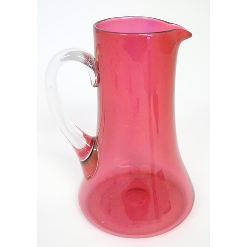 245 - A cranberry glass jug with clear glass loop handle. 10