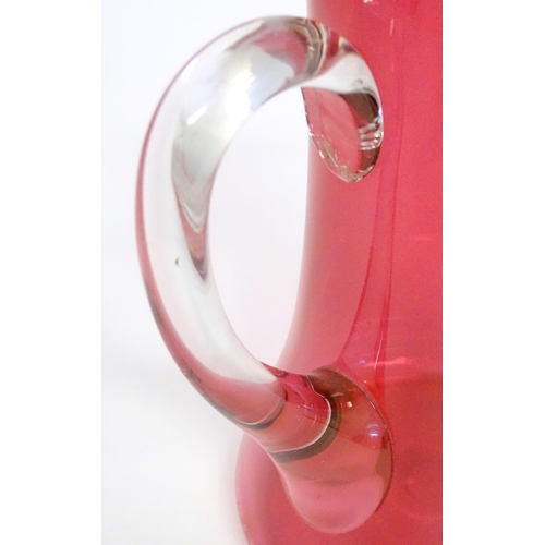 245 - A cranberry glass jug with clear glass loop handle. 10