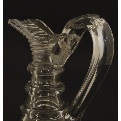 276 - A 19thC cut glass claret jug with facet cut detail and loop handle. 9