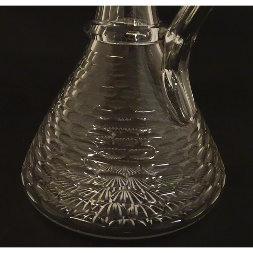 276 - A 19thC cut glass claret jug with facet cut detail and loop handle. 9