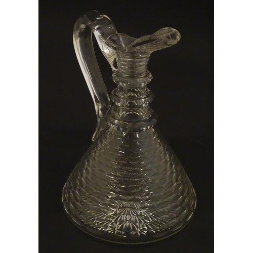 276 - A 19thC cut glass claret jug with facet cut detail and loop handle. 9