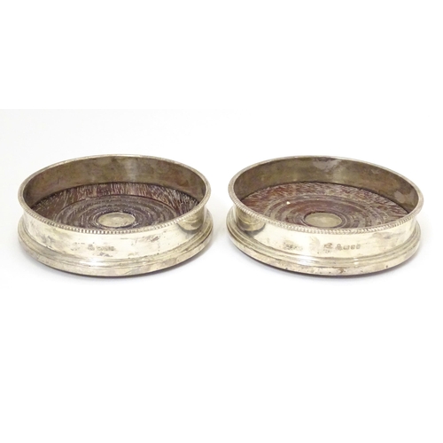 324 - A pair of silver coaster with turned wooden bases. Hallmarked London 1987 maker Payne & Son Approx 5... 