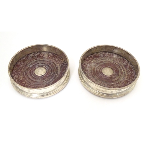 324 - A pair of silver coaster with turned wooden bases. Hallmarked London 1987 maker Payne & Son Approx 5... 