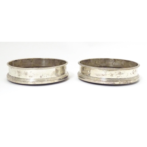 324 - A pair of silver coaster with turned wooden bases. Hallmarked London 1987 maker Payne & Son Approx 5... 