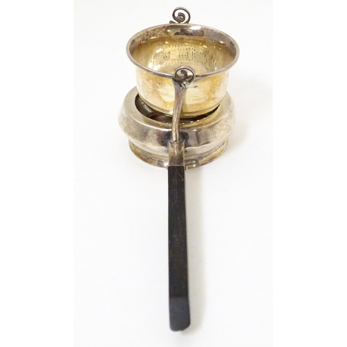 396 - A silver tea strainer modelled as a stylised teapot with suspended strainer above, the base with pou... 