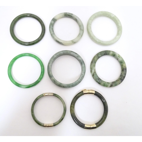 715 - A quantity of assorted bangle bracelets, some jade hardstone examples. (8)