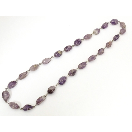 718 - A white metal and amethyst necklace. Approx. 28