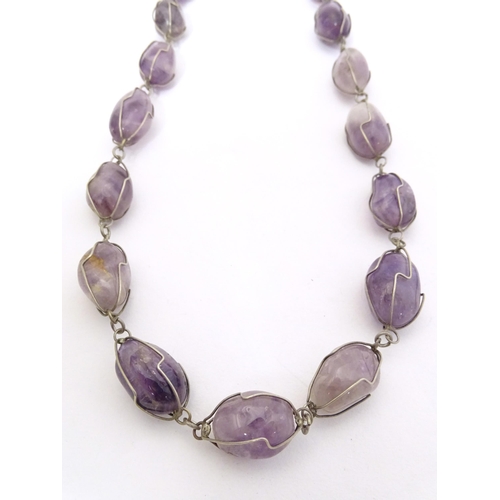 718 - A white metal and amethyst necklace. Approx. 28