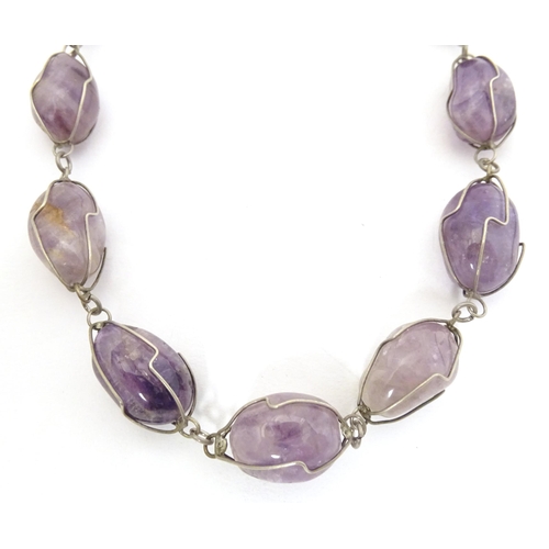 718 - A white metal and amethyst necklace. Approx. 28