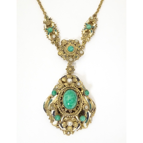 731 - A Continental gilt metal pendant and chain set with central cabochon and with enamel and bead detail... 