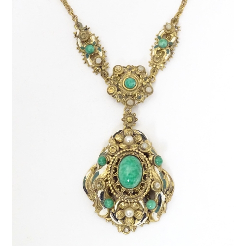 731 - A Continental gilt metal pendant and chain set with central cabochon and with enamel and bead detail... 