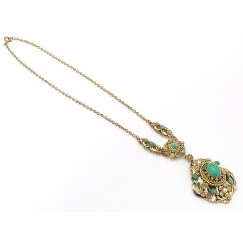 731 - A Continental gilt metal pendant and chain set with central cabochon and with enamel and bead detail... 