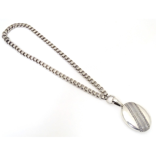 736 - A silver and white metal locket on chain, the locket with banded decoration. Locket approx. 2 1/2