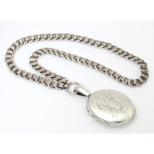 736 - A silver and white metal locket on chain, the locket with banded decoration. Locket approx. 2 1/2