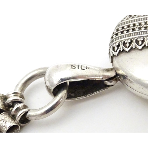 736 - A silver and white metal locket on chain, the locket with banded decoration. Locket approx. 2 1/2