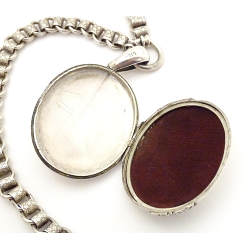 736 - A silver and white metal locket on chain, the locket with banded decoration. Locket approx. 2 1/2