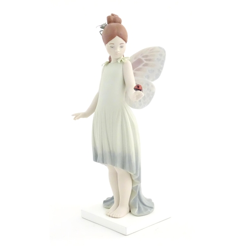 117 - A Lladro figure modelled as a fairy holding a ladybird / ladybug, Childhood Fantasy. Marked under, A... 