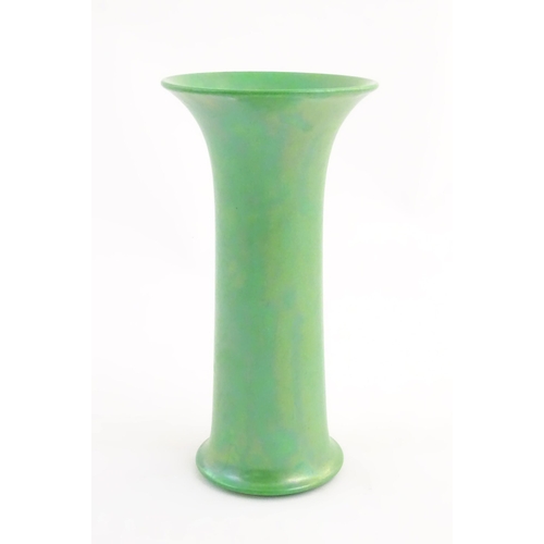 86 - A Ruskin pottery green lustre vase of cylindrical form with a flared rim. Impressed marks under 1918... 