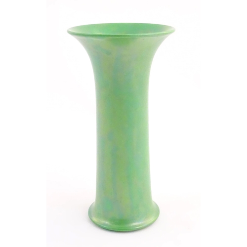 86 - A Ruskin pottery green lustre vase of cylindrical form with a flared rim. Impressed marks under 1918... 