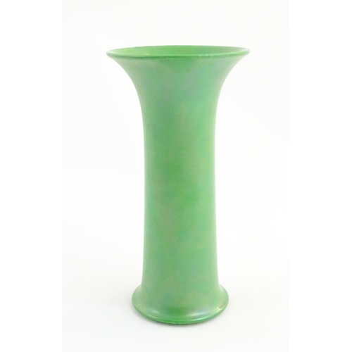 86 - A Ruskin pottery green lustre vase of cylindrical form with a flared rim. Impressed marks under 1918... 