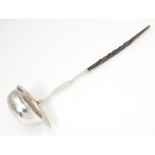 387 - A later 18th / early 19thC white metal toddy / punch ladle with a whale bone handle. Approx. 11 1/2