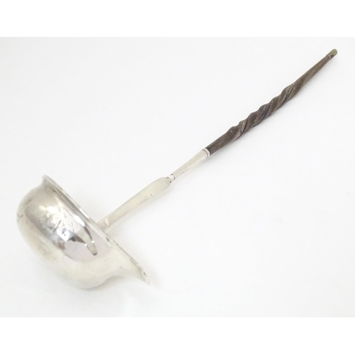 387 - A later 18th / early 19thC white metal toddy / punch ladle with a whale bone handle. Approx. 11 1/2