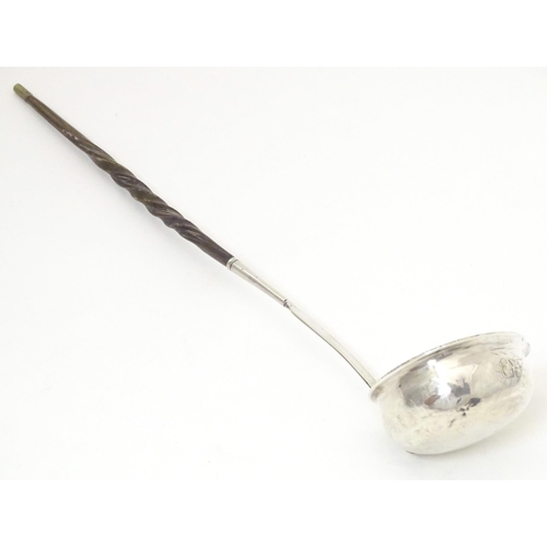 387 - A later 18th / early 19thC white metal toddy / punch ladle with a whale bone handle. Approx. 11 1/2