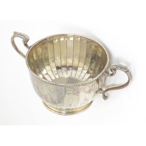 395 - A silver porringer with twin handles, hallmarked Birmingham 1925, maker Walker & Hall. Approx. 6