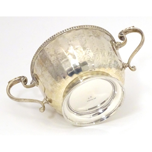 395 - A silver porringer with twin handles, hallmarked Birmingham 1925, maker Walker & Hall. Approx. 6