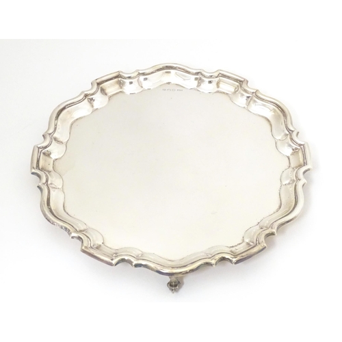 402 - A silver salver on three acanthus scroll feet, hallmarked Sheffield 1964, makers Viner's Ltd. Approx... 