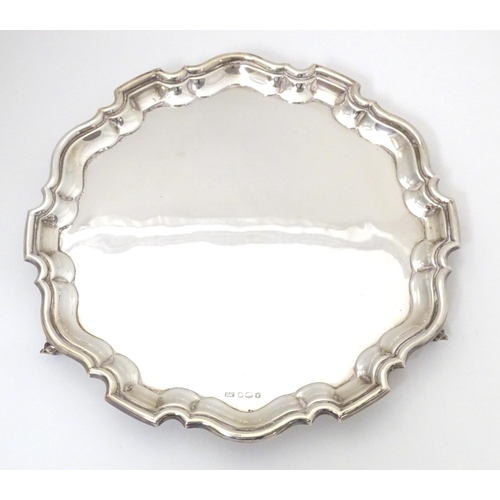 402 - A silver salver on three acanthus scroll feet, hallmarked Sheffield 1964, makers Viner's Ltd. Approx... 