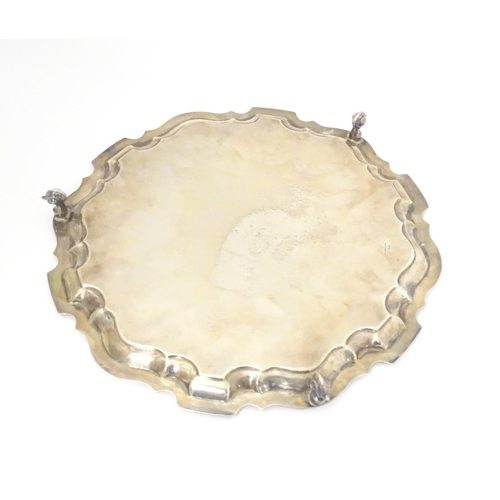 402 - A silver salver on three acanthus scroll feet, hallmarked Sheffield 1964, makers Viner's Ltd. Approx... 