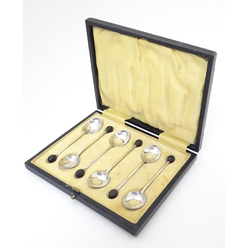 411 - A set of six silver coffee spoons the handles surmounted by coffee beans, hallmarked Birmingham 1924... 