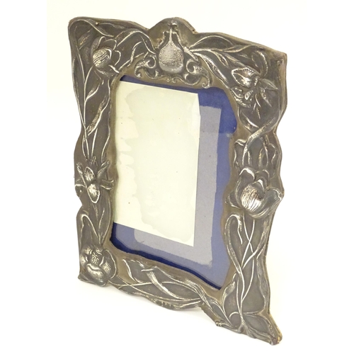 418 - An Art Nouveau photograph frame with silver surround decorated with embossed Art Nouveau floral deta... 