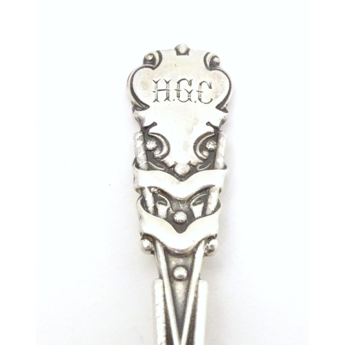 533 - A silver teaspoon the handle with gold club and ball decoration and engraved HGC, possible for Hamps... 